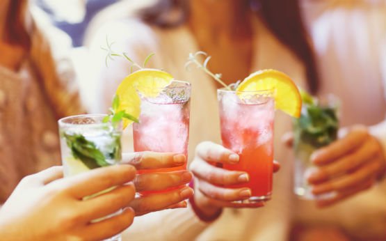 mulheres a fazerem brinde com cocktails alcoólicos