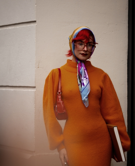mulher com vestido laranja e lenco atado na cabeca