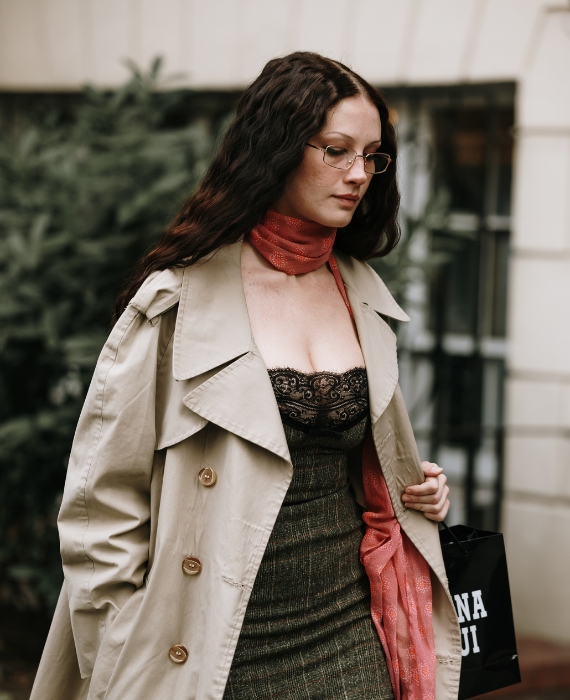 mulher com vestido gabardina e lenço ao pescoço